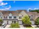 A row of well-maintained townhomes with colorful accents, driveways, and mature trees under a bright sky at 2131 Cass Lake Dr. # 662, Carolina Shores, NC 28467