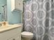 Well-lit bathroom featuring a white vanity, patterned shower curtain, and light blue walls at 233 Melody Gardens Dr., Surfside Beach, SC 29575