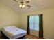 This bedroom has a ceiling fan and a window overlooking the grounds at 233 Melody Gardens Dr., Surfside Beach, SC 29575