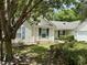 Charming single-story home with light siding, blue shutters, and mature landscaping at 233 Melody Gardens Dr., Surfside Beach, SC 29575