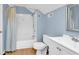 Bathroom with tub-shower combination, blue walls, and wood-look floors at 241 Black Duck Rd., Pawleys Island, SC 29585