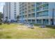 An exterior view displays an expanse of green space with lounge chairs and umbrellas, near the main building at 2501 S Ocean Blvd. # 503, Myrtle Beach, SC 29577