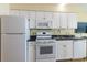 Bright kitchen features white cabinets, appliances, and black countertops at 2501 S Ocean Blvd. # 503, Myrtle Beach, SC 29577