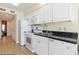 Clean kitchen features white cabinets, appliances, and a double sink with a view to the living room at 2501 S Ocean Blvd. # 503, Myrtle Beach, SC 29577