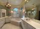 Bright bathroom featuring a tub, white cabinets, granite counters, and a chandelier at 274 Widgeon Dr., Pawleys Island, SC 29585