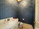 Cozy half bathroom with decorative wallpaper, white cabinets, and a toilet at 274 Widgeon Dr., Pawleys Island, SC 29585