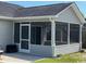 Close up of a screened-in porch with a ceiling fan and gray siding at 298 Weyburn St., Myrtle Beach, SC 29579