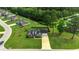 Aerial view of a brick home with lush greenery, pond, and serene surroundings in a well-maintained neighborhood at 301 Farmtrac Dr., Galivants Ferry, SC 29544