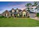 Inviting brick home with well-kept lawn, dormer windows, and an attached garage, all under a beautiful sky at twilight at 301 Farmtrac Dr., Galivants Ferry, SC 29544
