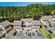Aerial view of the condo complex, showcasing the tan buildings, parking lot, and surrounding forest at 3015 Old Bryan Dr. # 4, Myrtle Beach, SC 29577