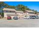 View of the condo complex with beige exterior, parking lot, wooden staircases, and surrounding trees at 3015 Old Bryan Dr. # 4, Myrtle Beach, SC 29577