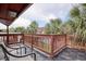 Outdoor deck with dark floors and wooden railing surrounded by lush green palm trees at 306 21St Ave. S # 5H, Myrtle Beach, SC 29577