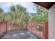 Cozy outdoor deck with dark floors and wood railing is lined with full green plants at 306 21St Ave. S # 5H, Myrtle Beach, SC 29577