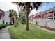 Exterior view of townhomes featuring white facades, red trim, and palm trees at 306 21St Ave. S # 5H, Myrtle Beach, SC 29577