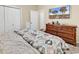 Bedroom with a large dresser, a TV, and a comfortable bed with neutral-colored walls at 3969 Murrells Inlet Rd., Murrells Inlet, SC 29576