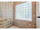 Close-up of the glass block walk-in shower with stone surround and a white tiled floor at 41 Sunfield Dr., Calabash, SC 28467