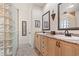 Bathroom featuring a double vanity, framed mirrors, and a walk-in shower with glass block wall at 41 Sunfield Dr., Calabash, SC 28467