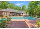 Backyard view showcasing a sparkling pool, screened-in porch, and lush greenery for ultimate relaxation and privacy at 41 Sunfield Dr., Calabash, SC 28467
