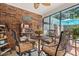 Cozy sunroom boasts brick accent wall, screened windows, and comfortable seating area for relaxation and enjoyment at 41 Sunfield Dr., Calabash, SC 28467