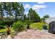 Lush backyard featuring a stone patio, palm trees, and manicured landscaping at 413 Goldenrod Circle # 2B, Little River, SC 29566