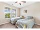 Bright bedroom with two twin beds, a ceiling fan, and natural light streaming through the window at 413 Goldenrod Circle # 2B, Little River, SC 29566