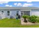 Back exterior of a light blue home with a well-kept lawn and landscape near the patio at 413 Goldenrod Circle # 2B, Little River, SC 29566