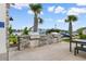 Outdoor kitchen area featuring stone countertops, built-in stainless steel grills, and palm trees at 413 Goldenrod Circle # 2B, Little River, SC 29566