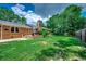 Spacious backyard with lush lawn, brick patio, and privacy provided by mature trees at 4189 Schoolhouse Circle, Little River, SC 29566