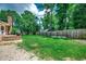 Expansive fenced backyard with well-maintained lawn, mature trees, and a small patio area at 4189 Schoolhouse Circle, Little River, SC 29566