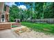 Large fenced backyard with a stone patio, grassy lawn, and mature trees offering privacy at 4189 Schoolhouse Circle, Little River, SC 29566