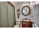 Bathroom with a dark vanity, toilet, round mirror, and a shower with green curtain at 4189 Schoolhouse Circle, Little River, SC 29566
