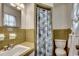 Bathroom featuring tiled walls, a patterned shower curtain, toilet, sink, and window at 4189 Schoolhouse Circle, Little River, SC 29566
