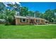 Well-maintained brick home with a lush green lawn, windows with black shutters, and solar panels at 4189 Schoolhouse Circle, Little River, SC 29566