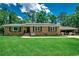 Charming brick home featuring manicured front lawn, solar panels, and covered carport at 4189 Schoolhouse Circle, Little River, SC 29566