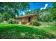 Brick home surrounded by lush lawn and mature trees with a fenced yard, and an air conditioning unit at 4189 Schoolhouse Circle, Little River, SC 29566