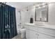 Well-lit bathroom with marble tile, vessel sink, framed mirror, commode, and tub/shower with blue shower curtain at 5511 N Ocean Blvd. # 1801, Myrtle Beach, SC 29577