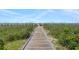 Scenic boardwalk view leading to the beach, lined with grassy dunes and colorful umbrellas at 5511 N Ocean Blvd. # 1801, Myrtle Beach, SC 29577