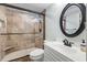 Modern bathroom with a tiled walk-in shower, updated vanity, oval mirror and modern fixtures at 5523 North Ocean Blvd. # 803, Myrtle Beach, SC 29577