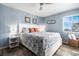 Light-filled bedroom with a ceiling fan, wood-look flooring, and blue wall decor at 5601 N Ocean Blvd. # E-113, Myrtle Beach, SC 29577