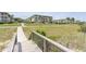 Condos at the beach with a wooden walkway leading from the street at 5601 N Ocean Blvd. # E-113, Myrtle Beach, SC 29577