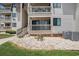 Condo exterior featuring a small patio with white rock landscaping, green grass, and an air conditioning unit at 5601 N Ocean Blvd. # E-113, Myrtle Beach, SC 29577