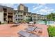 Exterior of a condo complex with a pool, deck with lounge chairs, and tables with umbrellas for relaxing by the pool at 5601 N Ocean Blvd. # E-113, Myrtle Beach, SC 29577