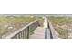 Wooden walkway leading to the beach with a view of the sand and ocean at 5601 N Ocean Blvd. # E-113, Myrtle Beach, SC 29577