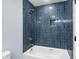 Modern bathroom features blue tiled walls, a shower head, and a white tub at 6001-Mh13A S Kings Hwy., Myrtle Beach, SC 29575