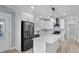 Close up of a kitchen with a black stainless refrigerator, a marble countertop island, and white cabinets at 6001-Mh13A S Kings Hwy., Myrtle Beach, SC 29575