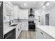 Kitchen with a black stainless stove and hood, a sink with marble countertops, and white cabinets at 6001-Mh13A S Kings Hwy., Myrtle Beach, SC 29575