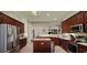 Spacious kitchen with dark wood cabinetry, stainless steel appliances, and island with open floor plan at 6400 Longwood Dr., Murrells Inlet, SC 29576