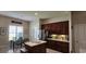Well-lit kitchen with dark wood cabinets, stainless steel appliances, island and adjacent dining area with a window at 6400 Longwood Dr., Murrells Inlet, SC 29576