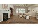 Cozy living room featuring a fireplace, built-in cabinets, and large windows overlooking the backyard at 6400 Longwood Dr., Murrells Inlet, SC 29576