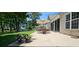 Inviting patio with outdoor seating and an umbrella, surrounded by lush greenery, ideal for relaxation at 6400 Longwood Dr., Murrells Inlet, SC 29576